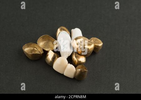 stamped brazed dental bridges covered with gold coated on black background Stock Photo