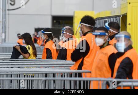 Dortmund, Germany. 19th Sep, 2020. Football: Bundesliga, Borussia Dortmund - Borussia Mönchengladbach, 1st matchday at Signal Iduna Park. Folders wear mask and face shield at the stadium entrance. IMPORTANT NOTICE: In accordance with the regulations of the DFL Deutsche Fußball Liga and the DFB Deutscher Fußball-Bund, it is prohibited to use or have used in the stadium and/or from the game taken photographs in the form of sequence images and/or video-like photo series. Credit: Bernd Thissen/dpa/Alamy Live News Stock Photo