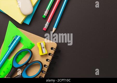 School supplies on black chalkboard with copy space, top view Stock Photo