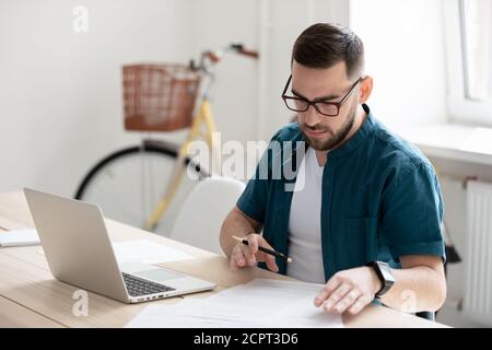 Serious young businessman wearing glasses working with documents Stock Photo