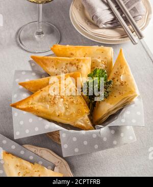 Puff pastry triangles stuffed with cheese, typical from Greece. Stock Photo