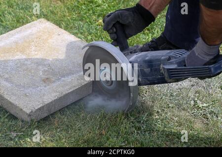 Industrial construction worker using a professional angle grinder Stock Photo