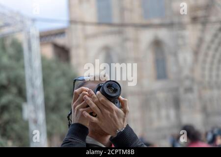 BARCELONA, SPAIN - NOVEMBER 23, 2019: A tourist takes pictures of the cathedral of Barcelona. Stock Photo