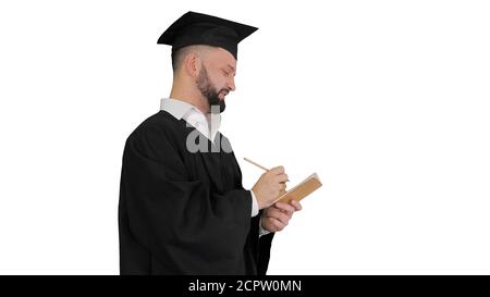 Thoughtful graduation man writing down his goals on white backgr Stock Photo