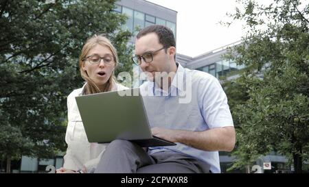 Smart friends man and woman using laptop. Stock Photo