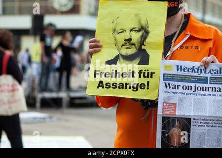 BERLIN - September 19: Man holds 'Freedom for Assange' poster. People demonstrate against the extradition of publisher Julian Assange to the United States, at a protest on 19 Sep 2020 in Berlin. Assange is wanted by the US government for distributing military documents that showed evidence of war crimes, and faces extradition from the UK to the US. Stock Photo