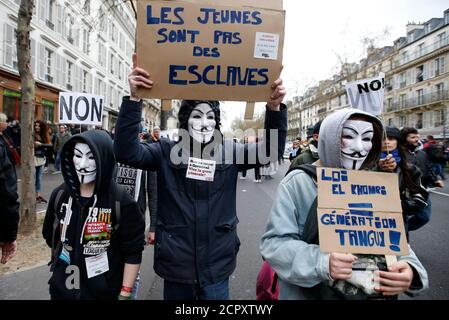 Protestors wearing Guy Fawkes masks attend a demonstration against the French labour law proposal in Paris, France, April 9, 2016. The slogan reads 'The youths are not slaves'.  REUTERS/Charles Platiau