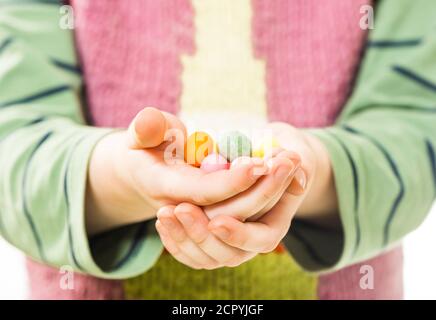 Little caucasian boy holding colorful candies in open palms Stock Photo