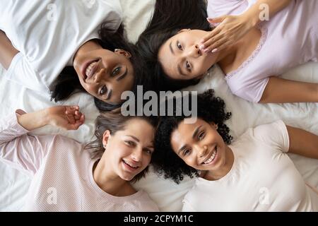 Happy young mixed race women having fun at pajamas party. Stock Photo