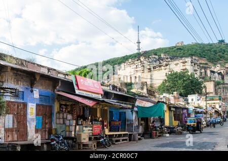 Bundi street and shops with Garh palace and Taragarh Fort in the background, Bundi, India Stock Photo