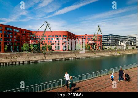 Inner harbor Duisburg with the wave-shaped building from the State Archives NRW, other modern office buildings and old harbor cranes, Duisburg, Ruhr Stock Photo