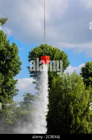 Police helicopter during an operational exercise with the BAMBI BUCKET extinguishing water tank, Düsseldorf, North Rhine-Westphalia, Germany Stock Photo