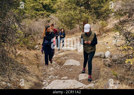 Hikers travel along a beautiful mountain route. International mountain day. Bishkek, Kyrgyzstan - April 9, 2019 Stock Photo