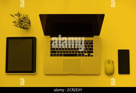 Office workplace with laptop, notebook, hand, office supplies, on yellow background. Solution, business planning, financial analysis, accounting Stock Photo