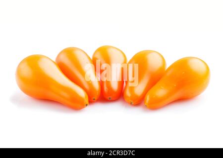 Five small ripe orange grape tomatoes isolated on white background. side view, close up. Stock Photo