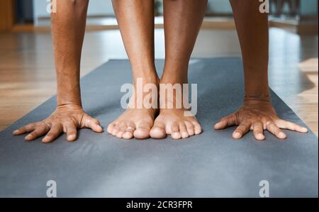 Standing Forward Bend pose in yoga iyengar, Uttanasana fold pose close up front view in studio Stock Photo
