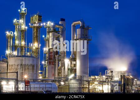 Oil refinery with a cooling tower with free cooling after sunset with lights Stock Photo