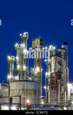 Petroleum refinery with a cooling tower with free cooling after sunset with lights Stock Photo