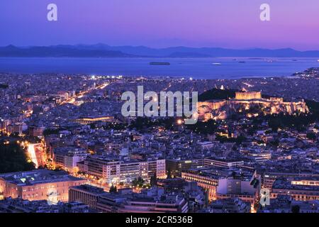 Panoramic view of Athens and Acropolis shot from Lycabettus hill. Parthenon lit up by night lights. Famous iconic view of UNESCO world heritage site. Stock Photo