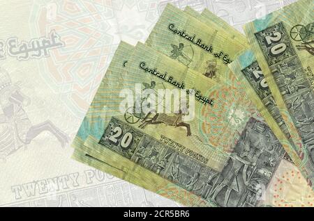 20 Egyptian pounds bills lies in stack on background of big semi-transparent banknote. Abstract presentation of national currency. Business concept Stock Photo