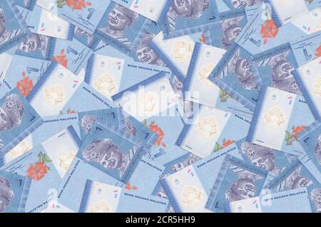 1 Malaysian ringgit bills lies in big pile. Rich life conceptual background. Big amount of money Stock Photo