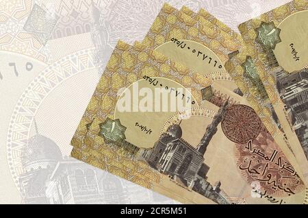 1 Egyptian pound bills lies in stack on background of big semi-transparent banknote. Abstract presentation of national currency. Business concept Stock Photo