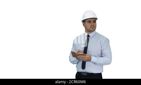 Man in helmet and formal clothes walking looking around and making notes on white background. Stock Photo