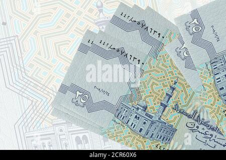 25 Egyptian piastres bills lies in stack on background of big semi-transparent banknote. Abstract presentation of national currency. Business concept Stock Photo