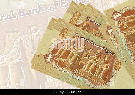 1 Egyptian pound bills lies in stack on background of big semi-transparent banknote. Abstract presentation of national currency. Business concept Stock Photo