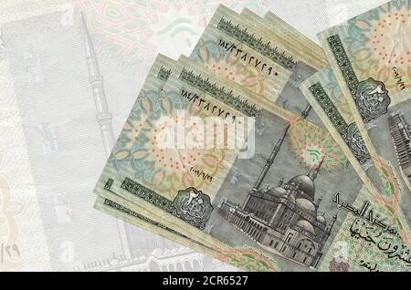 20 Egyptian pounds bills lies in stack on background of big semi-transparent banknote. Abstract presentation of national currency. Business concept Stock Photo