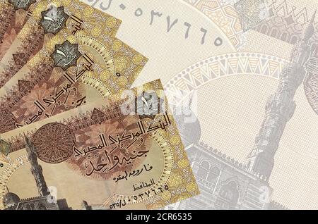 1 Egyptian pound bills lies in stack on background of big semi-transparent banknote. Abstract business background with copy space Stock Photo