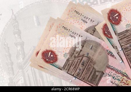 10 Egyptian pounds bills lies in stack on background of big semi-transparent banknote. Abstract presentation of national currency. Business concept Stock Photo