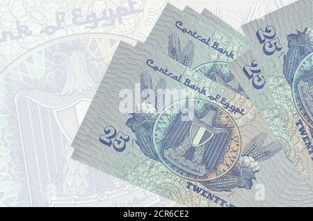 25 Egyptian piastres bills lies in stack on background of big semi-transparent banknote. Abstract presentation of national currency. Business concept Stock Photo