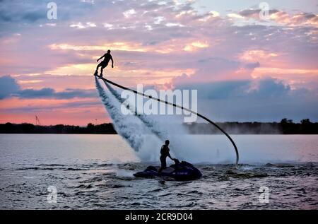 Rocket Man flying on a Jet Fly Board at sunset in Lake Arlington ,Texas . Stock Photo
