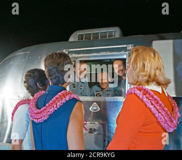 The Apollo 11 crewmen, still under a 21-day quarantine, are greeted by their wives. Stock Photo