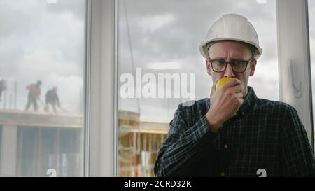Construction worker eating an apple. Stock Photo