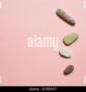 Natural pebble stones on pink background. top view, copy space Stock Photo