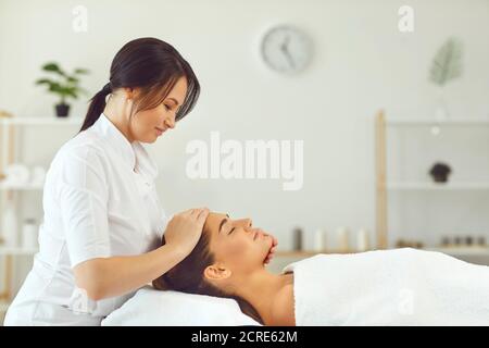 Smiling woman dermatologist making professional manual relaxing massage for young woman Stock Photo