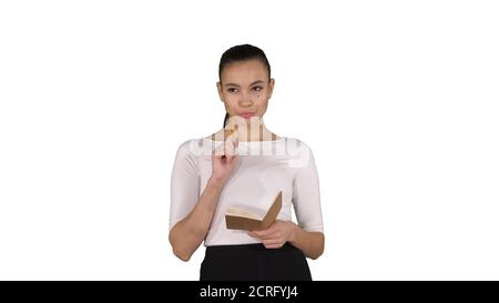 Young woman making notes while walking on white background. Stock Photo