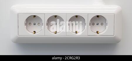 Four electric white outlet socket on gray wall EU standard. Banner format. Stock Photo