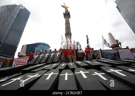 Mock coffins, symbolising the 65 miners that died in an explosion at Grupo Mexico's Pasta de Conchos coal mine, are displayed at the Angel of the Independence monument during a protest to mark the 12th anniversary of the disaster, in Mexico City, Mexico February 19, 2018. REUTERS/Ginnette Riquelme