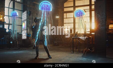 Female Artist Wearing Augmented Reality Headset Working on Abstract 3D Jellyfish Sculpture with Joysticks, Uses Gestures To Create High-Tech Internet Stock Photo