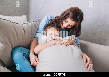 Little boy laughing and playing with mom at home