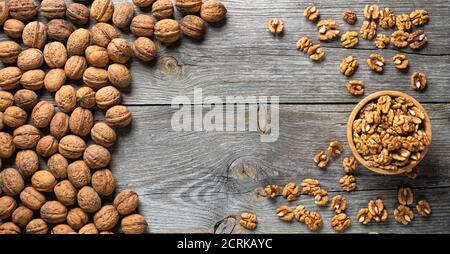 Fresh walnut kernels and whole walnuts in a bowl on rustic old wooden table. Healthy organic food, BIO viands, natural background. Copy space for your Stock Photo