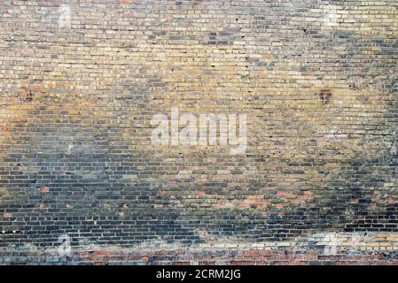 Weathered stained old brick wall background on surface Stock Photo
