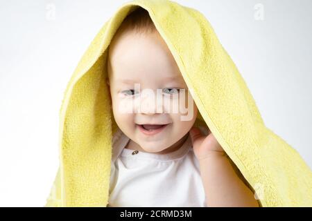 Photo of hidden eleven-month-old baby under yellow towel Stock Photo