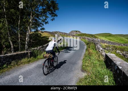 Male cyclist riding between Airton and Settle in the Yorkshire Dales, UK Stock Photo