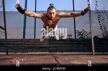 Athletic man doing push-up exercise with jumps Stock Photo