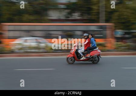 Panning technique of red bike going somewhere at evening on the road. Stock Photo