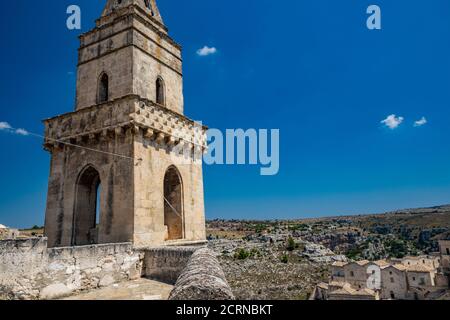Matera, Basilicata, Italy - The bell tower of the cave church of San Pietro Barisano, with the Murgia Materana Park in the background. Stock Photo